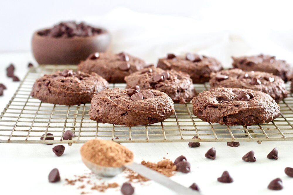 Double Chocolate Fudge Breakfast Cookies on cooling rack with cocoa powder and chocolate chips