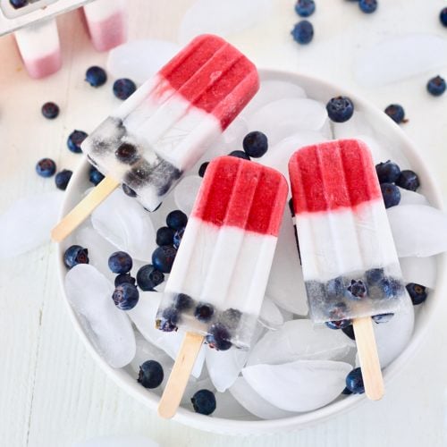 Homemade red white and blue popsicles 13 | Milk & Honey Nutrition red white and blue fruit popsicles in bowl of ice