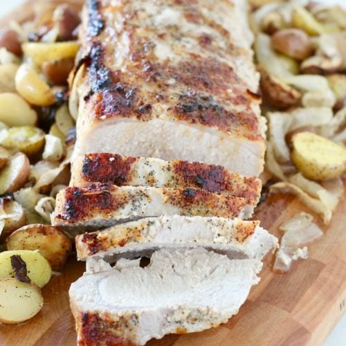 sheet pan boneless pork loin and potatoes 1 | Milk & Honey Nutrition pork loin roast with onions and potatoes on wooden cutting board