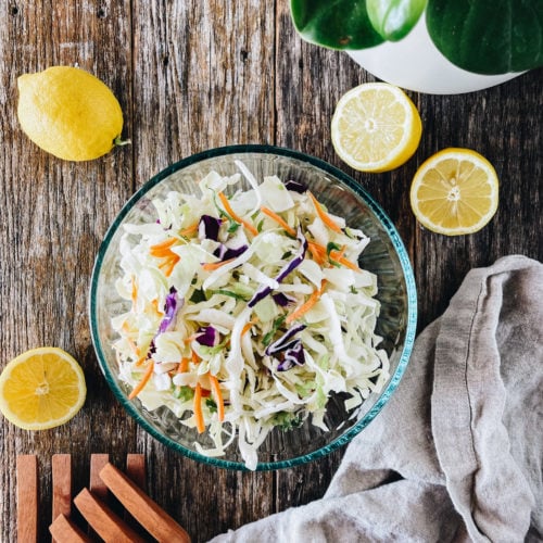 low carb coleslaw 1 | Milk & Honey Nutrition low carb coleslaw in clear bowl with lemons