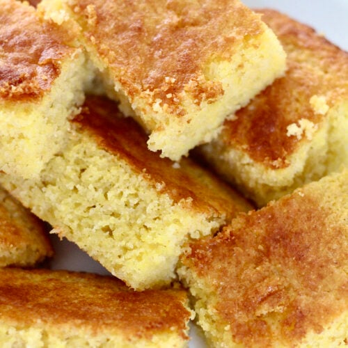 protein cornbread 2 | Milk & Honey Nutrition Squares of golden almond flour cornbread stacked on a white plate