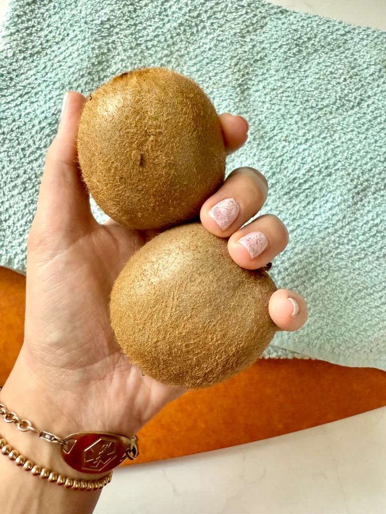 hand holding 2 kiwifruit