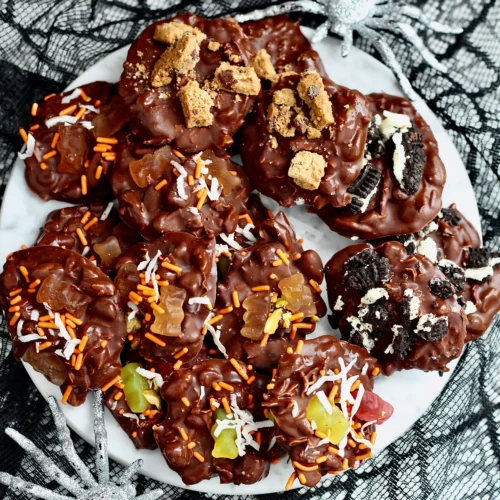sugar free halloween candy clusters on white marble platter with silver glitter spiders